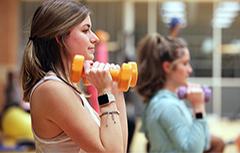 Female student lifting dumbbells